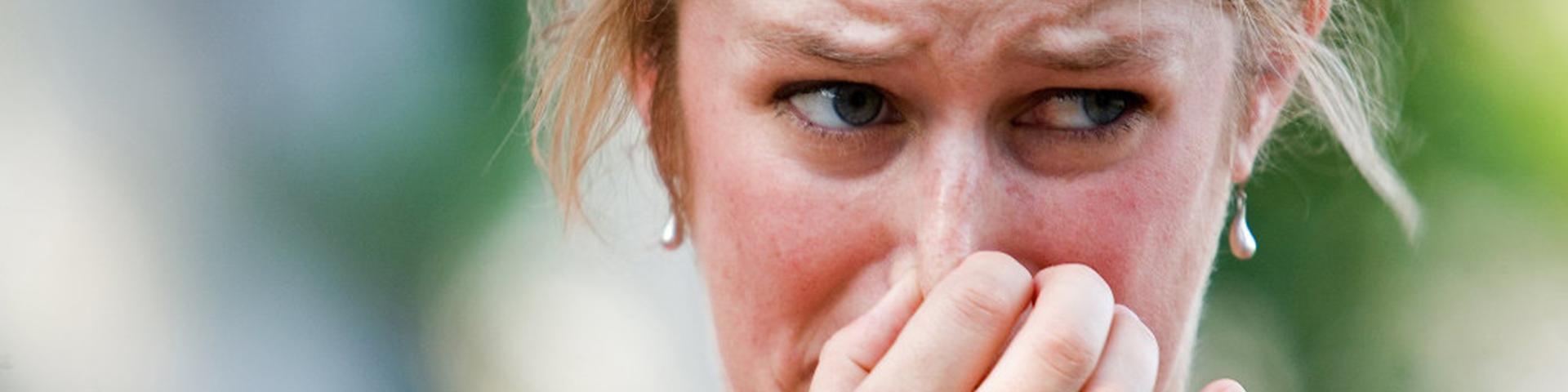 Vrouw knijpt neus dicht