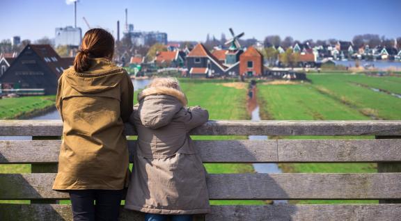 vrouw en kind kijken uit over de weilanden bij de zaanse schans